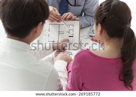 Couple meeting architect for plans of future home