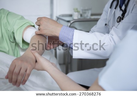 Portrait of doctor giving first aid to patient in hospital