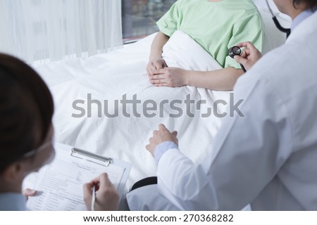 Doctor listening to heartbeat of man