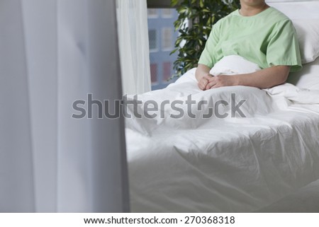 Thoughtful male patient lying on bed in hospital