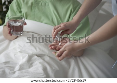 Nurse giving glass of water to sick man