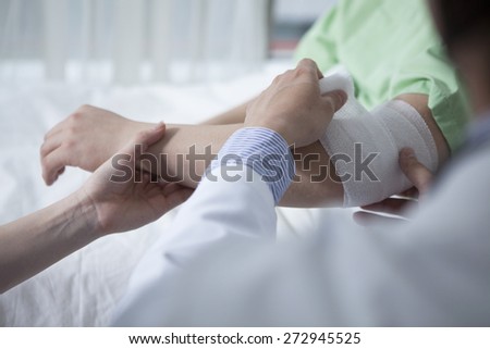 Portrait of confident doctor giving first aid to male patient in hospital
