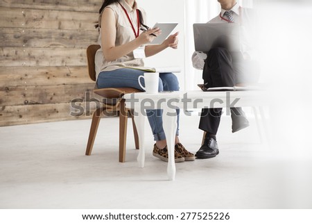 Two business people sitting in the chair discussing