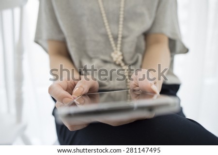 Asian woman sit on chair use cellphone.
