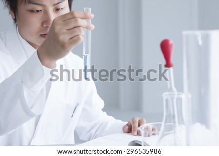 Closeup of a male scientist filling test tubes with pipette in laboratory