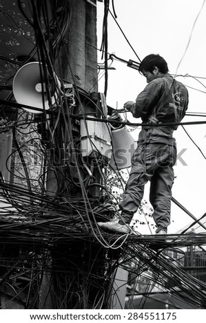 23 November 2013 in Hanoi Vietnam, Unknow electrical worker working, Black and white colour