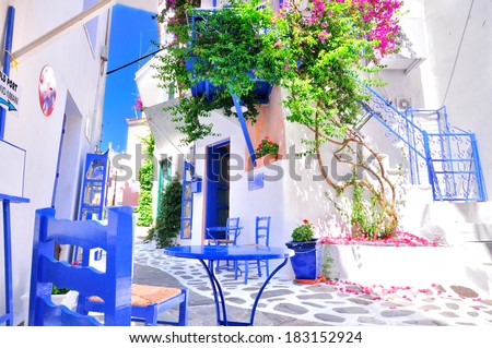 Typical greek traditional village in summer with white walls, blue furniture and colorful bougainvilla, Skiathos Island, Greece, Europe