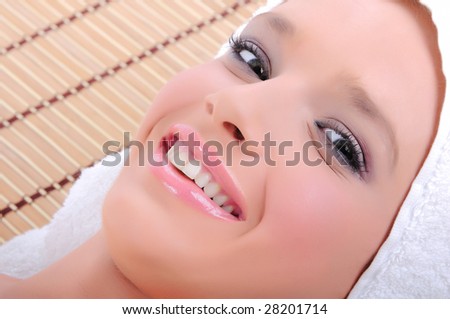 Head shot of a pretty young woman smiling before starting a spa/massage treatment
