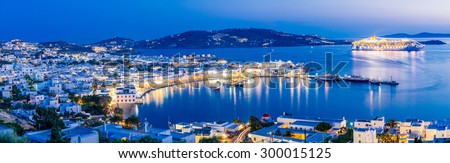 Panorama of Mykonos town at evening with islands and cruise ship in the distance, Mykonos island, Cyclades, Greece