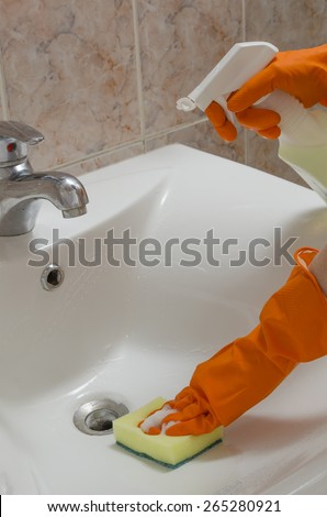 cleaning sinks in the orange gloves