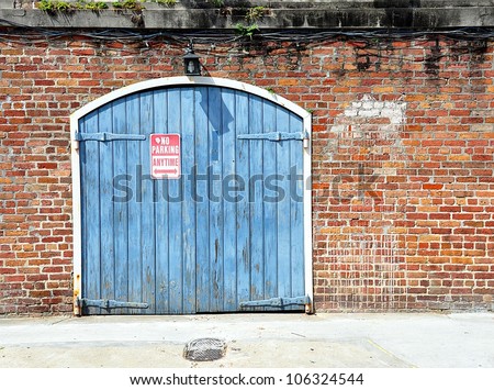 Brick Wall With Blue Garage Doors In New Orleans French Quarter