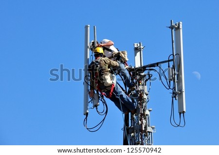 Two Men Working On A Telecommunication Tower