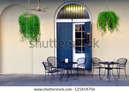 A Quaint Sidewalk Cafe In The New Orleans French Quarter With Hanging Ferns