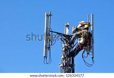 Two Technicians Working On A Telecommunication Tower
