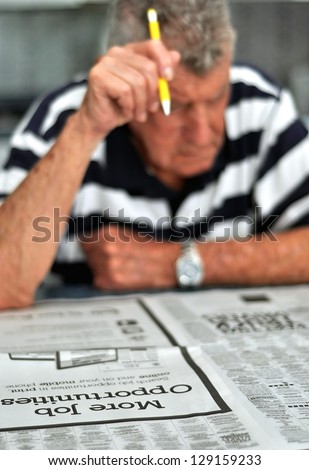Elderly Caucasian Man Searching Classified Ads For Employment