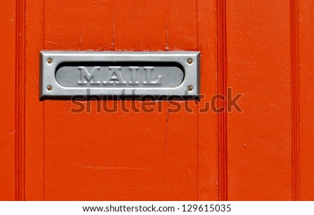 Closeup Of Metal Mail Slot On Orange Door In New Orleans French Quarter