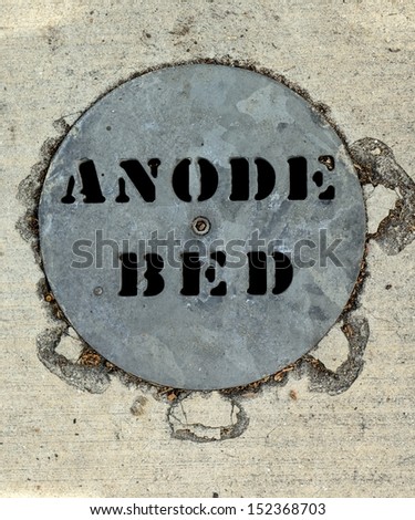 A Round Anode Bed In A Cement Sidewalk