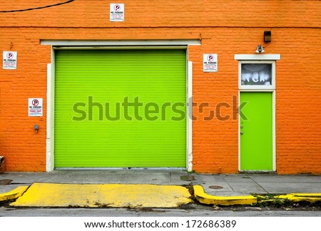 A Funky, Brightly Painted Garage Front With Overhead Door And Entry Door