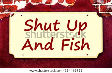 A Beige Placard Sign On Maroon Stucco And Brick Background With The Saying \