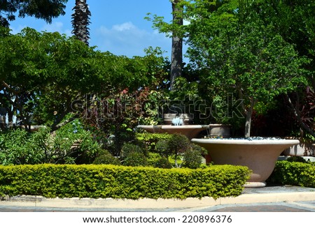 A beautifully landscaped outdoor garden with large planters and water fountains.