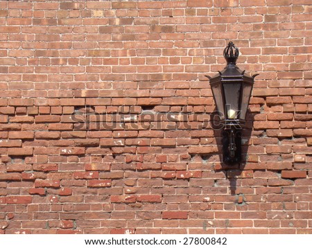 Wrought iron lantern on brick wall