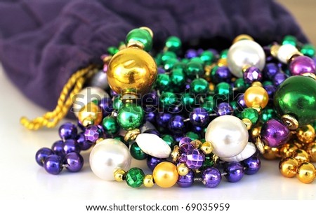 Selective Focus On Mardi Gras Beads Spilling From A Purple Velvet Drawstring Sack