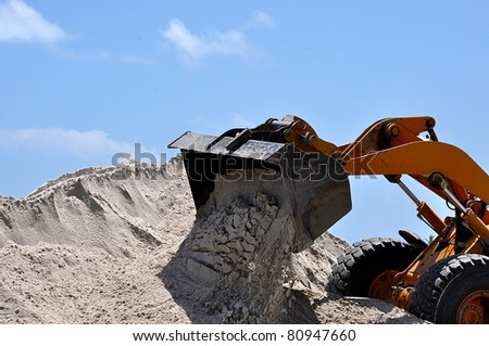 Closeup Of A Bulldozer Loading Sand On A Beach