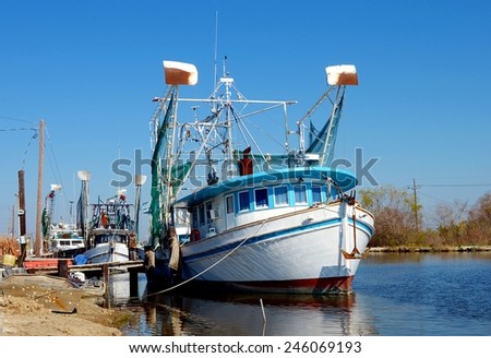 Colorful old wooden shrimp boat trawlers docked along Bayou Lafourche in South Louisiana.