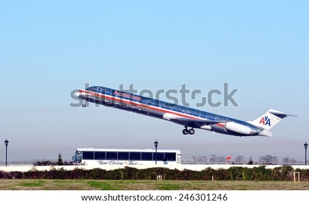 NEW ORLEANS, LA.-JANUARY 19: An American Airline Passenger Jet departing New Orleans International Airport on January 19, 2015, as a New Orleans Tours bus passes underneath.