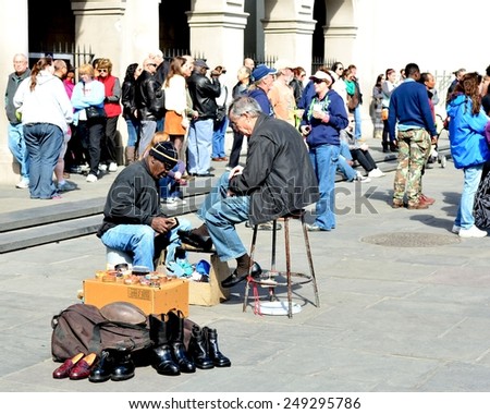 NEW ORLEANS, LA-JAN.31: A shoe shine man near Jackson Square in the New Orleans French Quarter polishes the shoes of a tourists in town for Mardi Gras on January 31, 2015.
