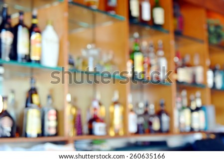 Blurred background image of bar back with shelves of liquor bottles.