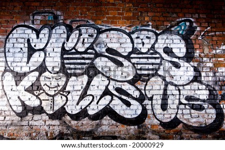 stock photo : Black and white graffiti inscription Crisis Kills Us on brick 