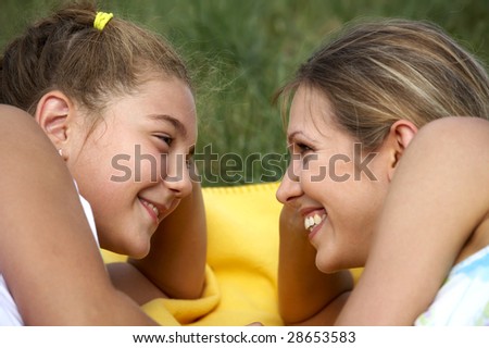 Funny mom and daughter smiling outdoors