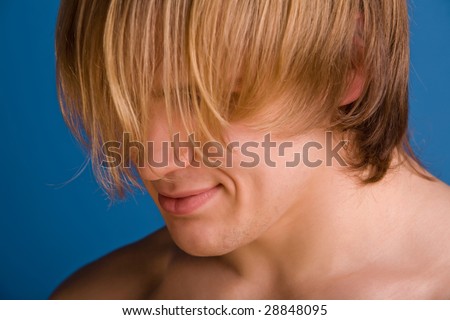 Confused blond man covering his face
