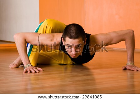 Young muscular dancer posing in dance hall