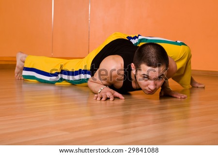Young muscular dancer posing in dance hall