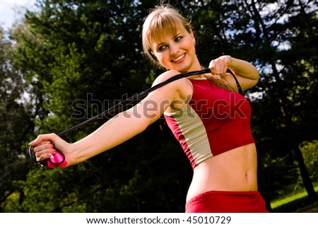 Funny lovely woman with a skipping rope outdoors