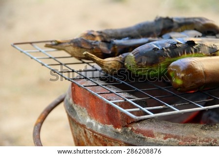 Grilled eggplants on earthen stove, old style Asian cooking/Old style eggplants grilled