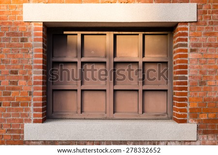 Metal window inside red brick wall background