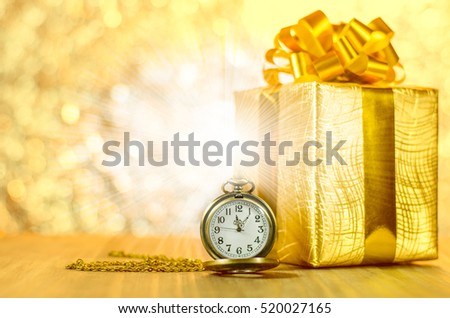 Vintage pocket watch with gold christmas gift box, ribbon and bow on lights effect background