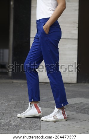 woman in blue trousers, loose fit, white shoes, nice legs, blue trousers