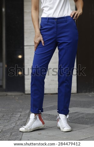 woman in blue trousers, loose fit, white shoes, nice legs, blue trousers