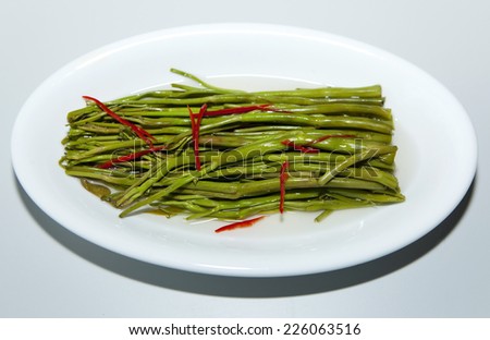Stir fried water spinach with oyster sauce on a white plate