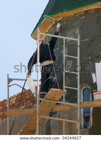 The worker with the tool on a roof