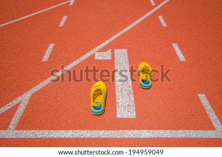 Yellow sport shoes on athletic track