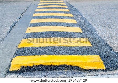 Yellow stripe speed ramp on an asphalt road