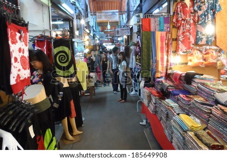 Bangkok, Thailand Ã¢Â?Â? May 4, 2013: Market stalls, vendors and customers at Chatuchak weekend market. Customers choose T-shirt from a stall. Chatuchak market is the biggest market in Bangkok.