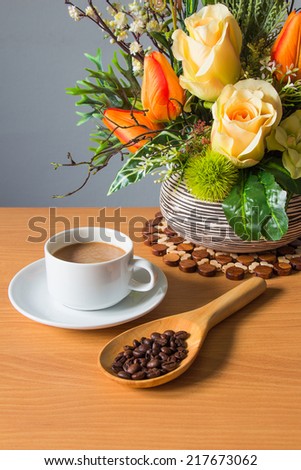 still life with cup of coffee and flower on wooden table