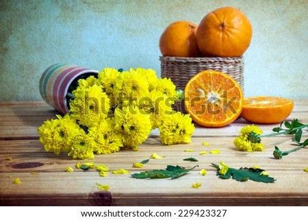 Still life with flowers and fruits on wooden table over grunge background