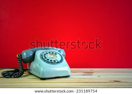 Still life with retro phone on wooden table over grunge background